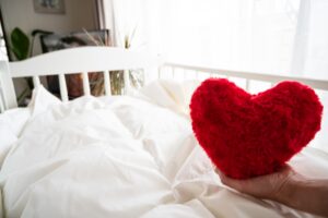 ベビーベッドの中に赤いハートのクッション