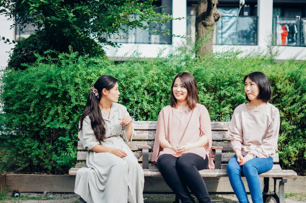 ベンチで会話する3人の女性