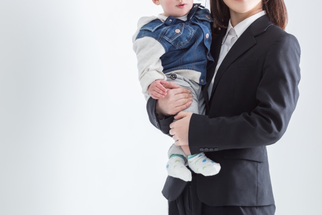 子供を抱くスーツを着た女性