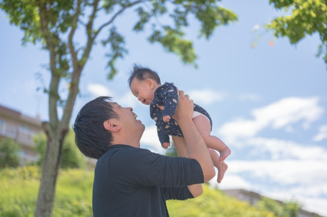 外で父親に抱っこされる赤ちゃん