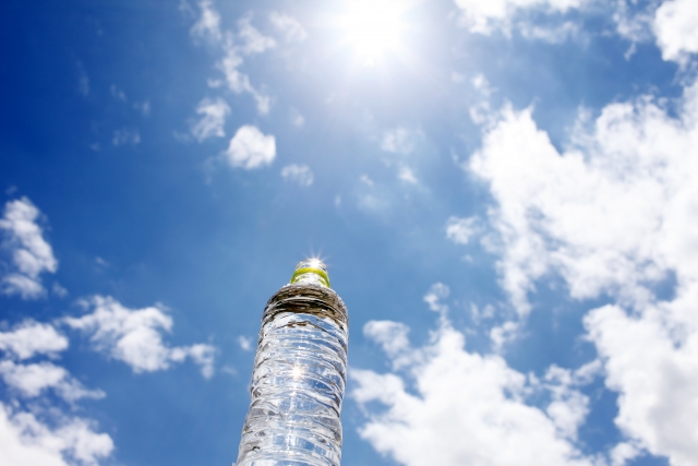 青空の下に水の入ったペットボトル