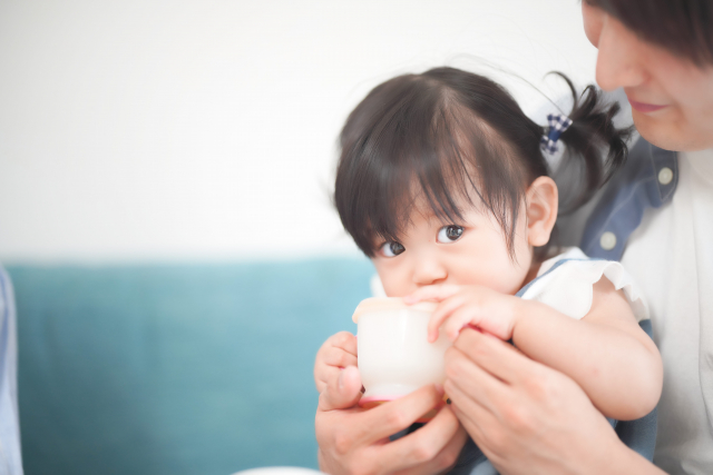 飲み物を飲んでいる0歳の女の子