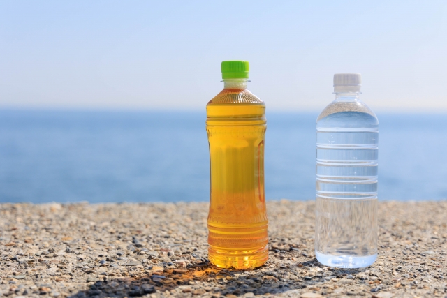 海辺に置かれているペットボトルのお茶と水