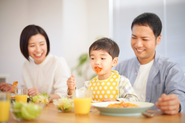 楽しそうに食事をする家族