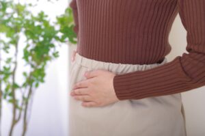 お腹に手を当てる女性