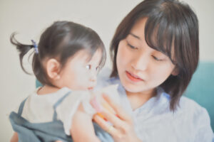 子供にコップで飲ませようとする母親